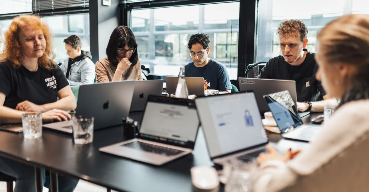 Team arbeitet in einem KI-Workshop gemeinsam an Laptops