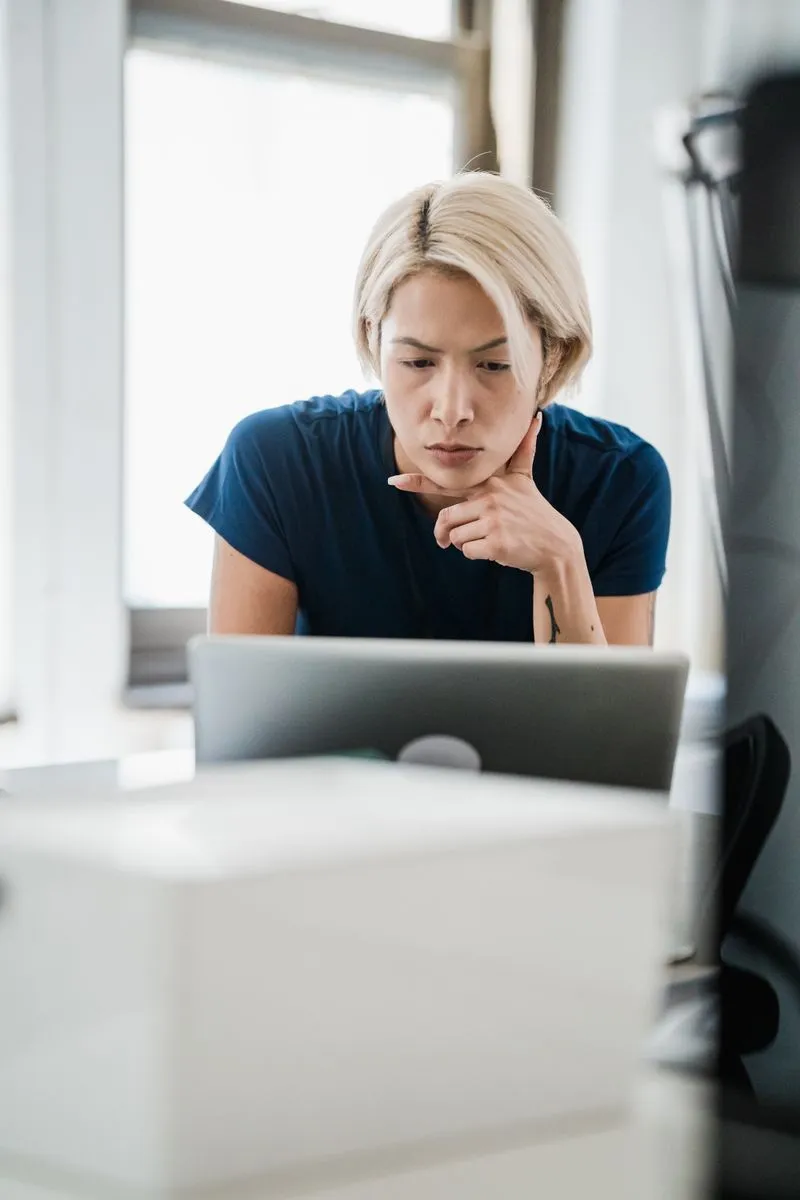 Person arbeitet konzentriert und reflektiert am Laptop